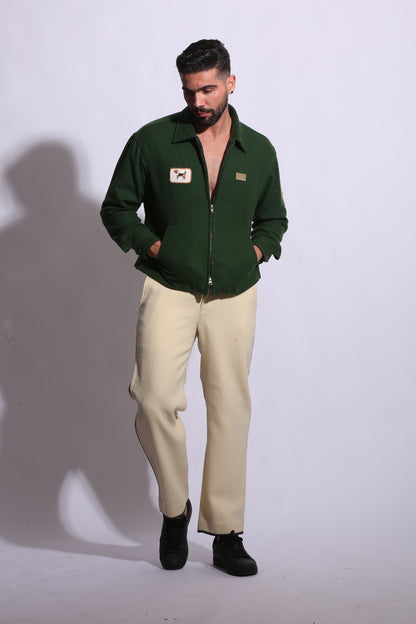 Person wearing a green jacket and beige pants on a white background