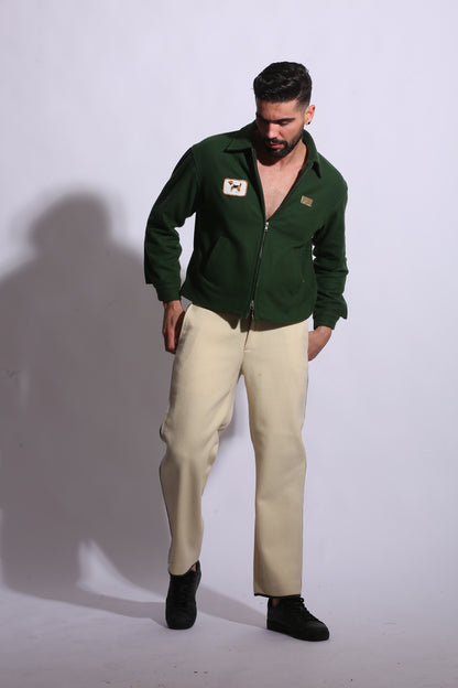 Person wearing a green jacket and beige pants on a white background