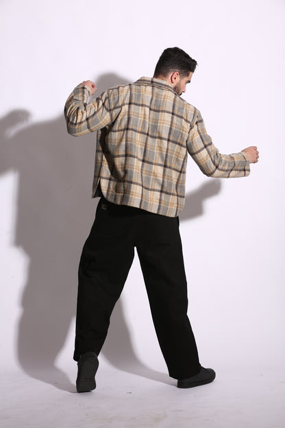Person wearing a plaid shirt and black pants on a white background