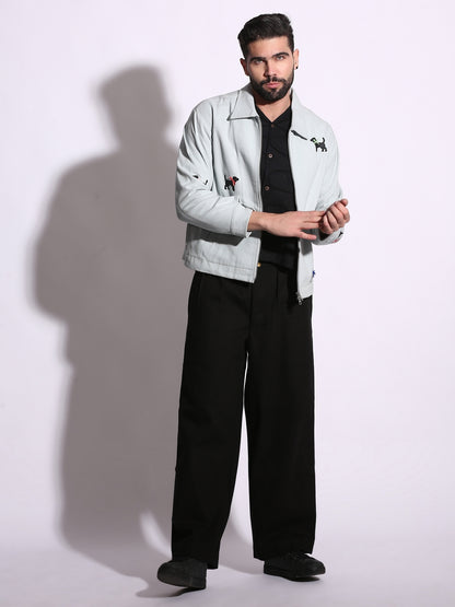 Man wearing a light gray jacket and black pants on a white background