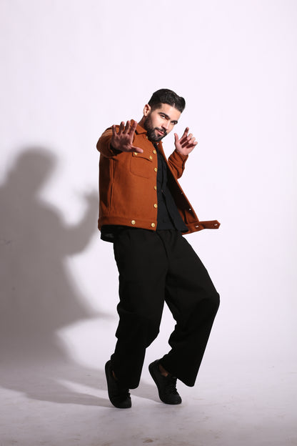 Person wearing a brown jacket and black pants on a white background