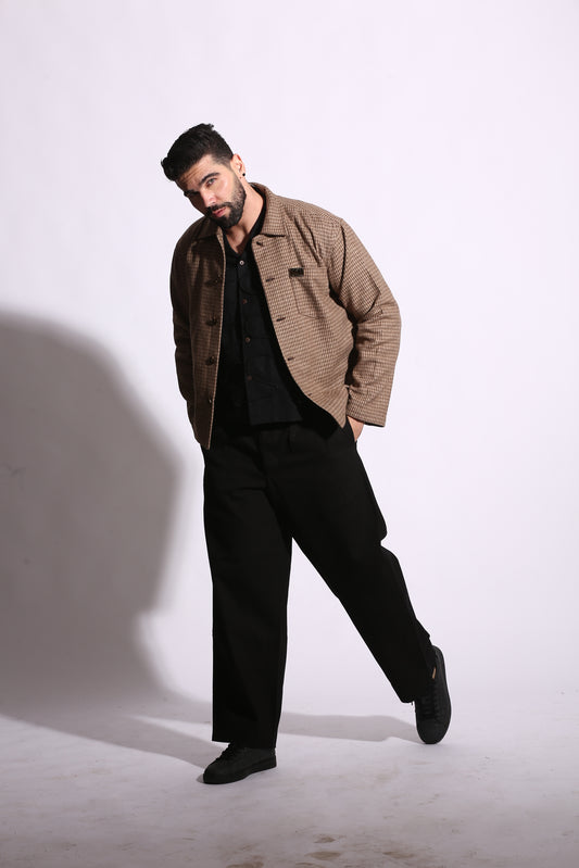 Man wearing a brown coat and black pants on a white background