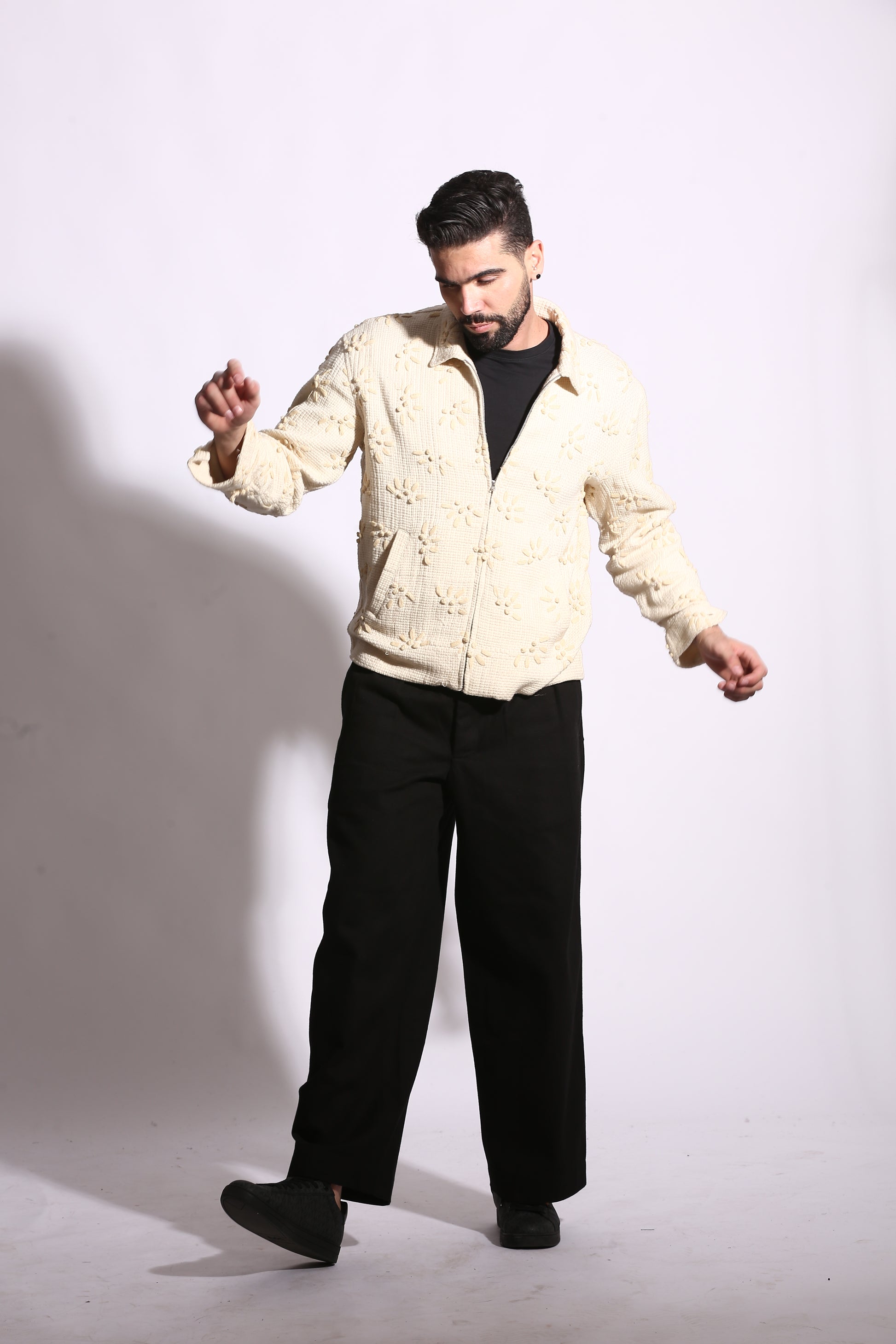 Man lying on a white floor with a neutral expression