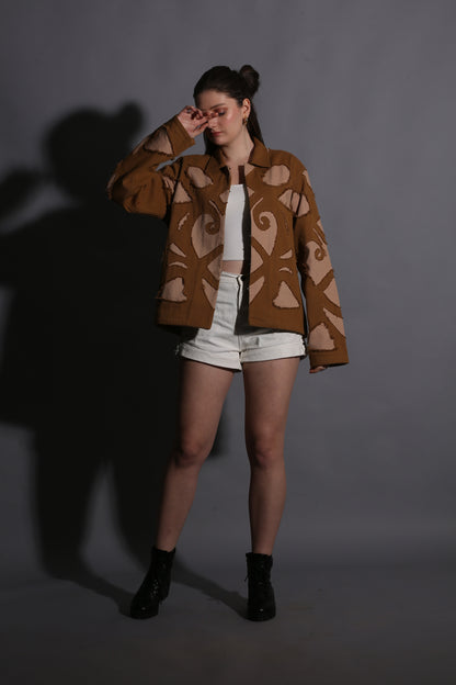 Person wearing a patterned brown coat on a dark background