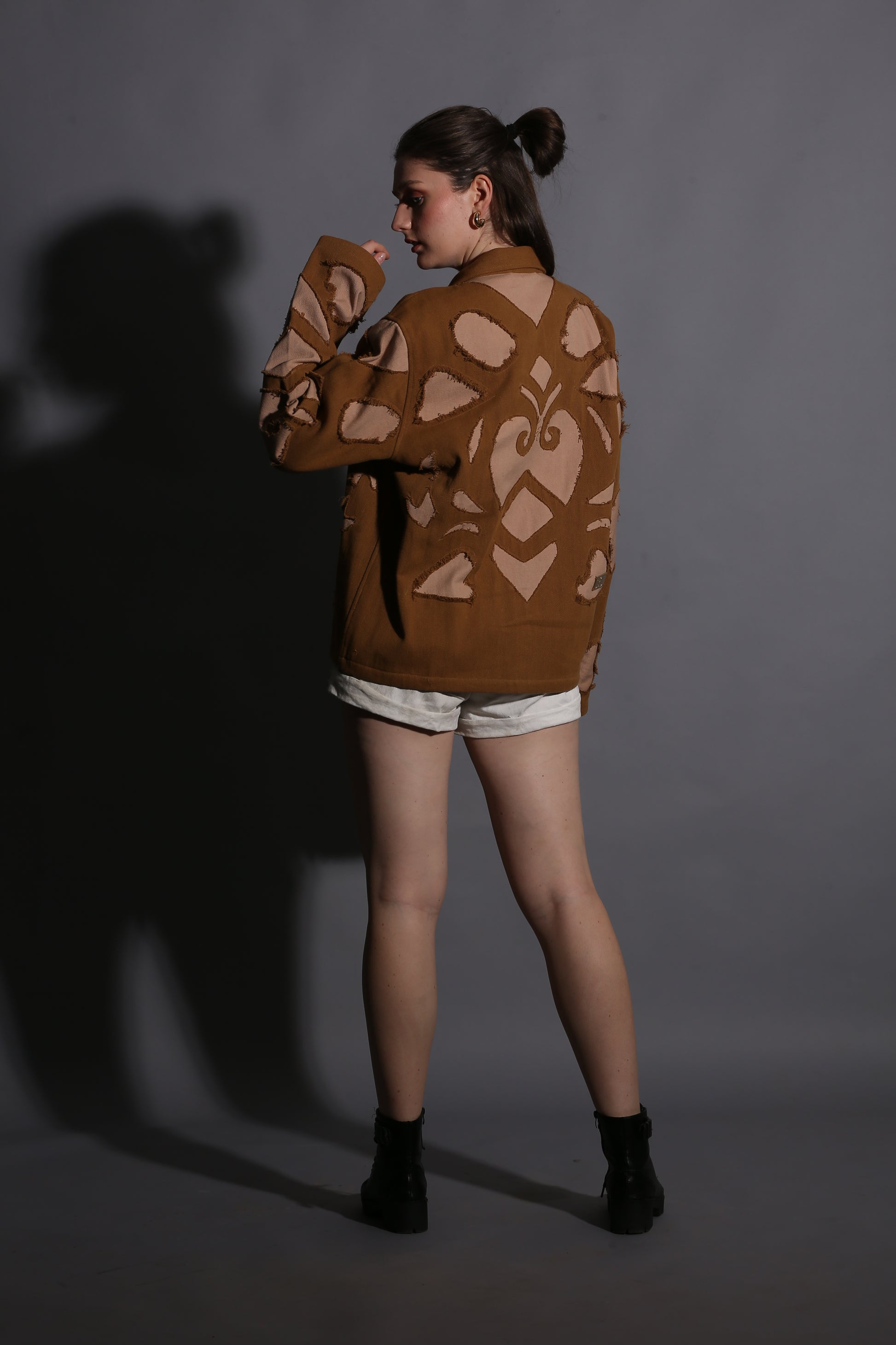 Person wearing a brown patterned sweater against a dark background