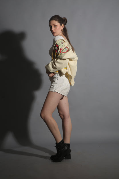 Person wearing a patterned top and shorts on a plain background
