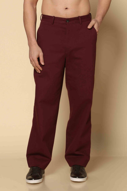 Maroon pants worn by a person on a beige background