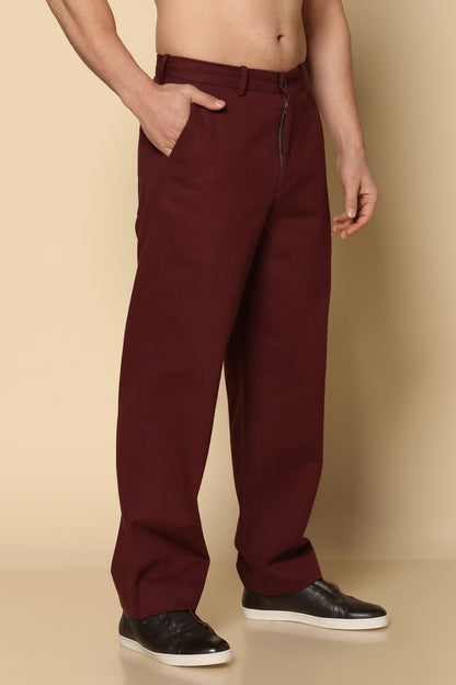 Maroon pants worn by a person on a beige background