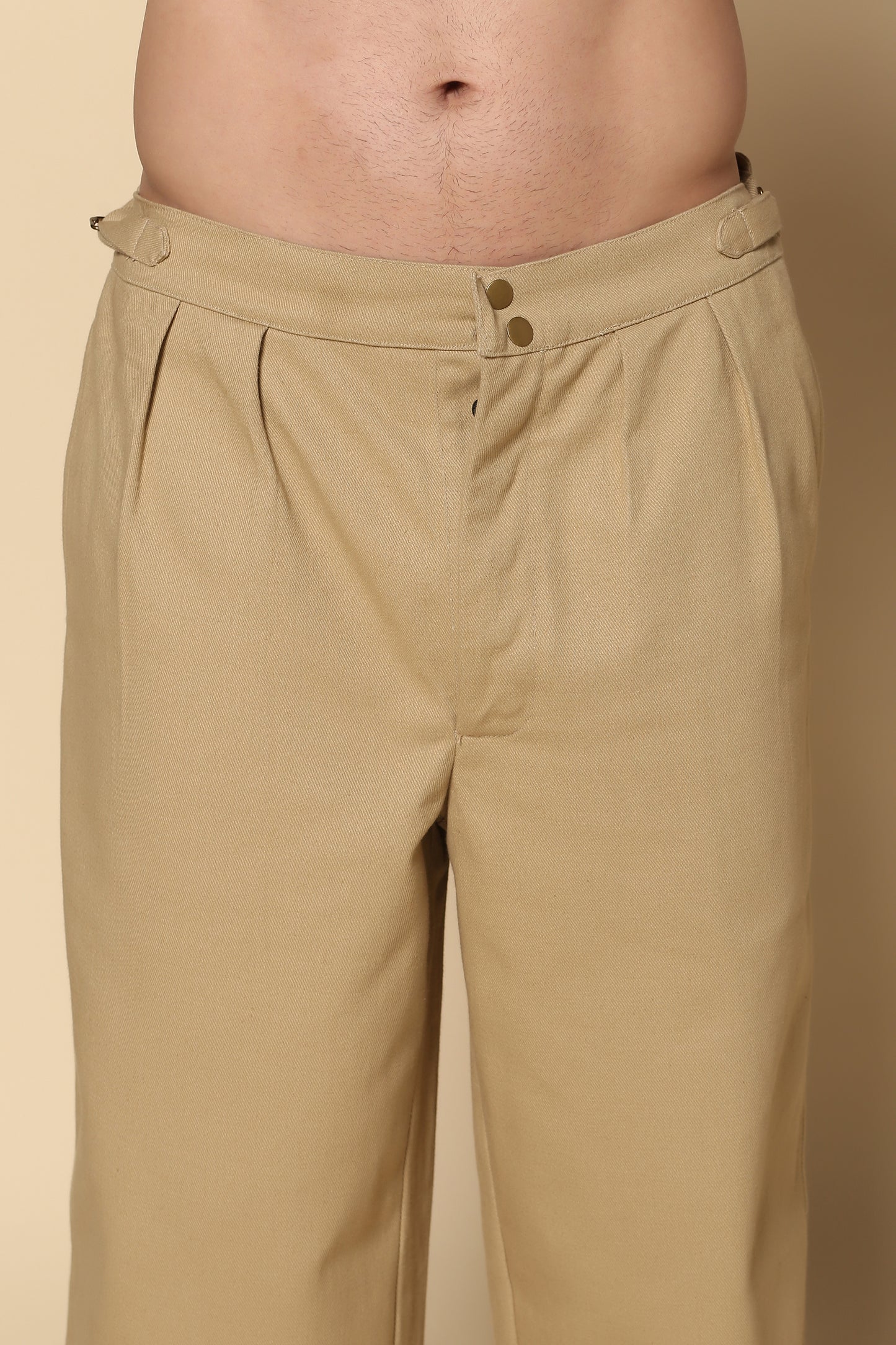 Beige pants worn by a person on a beige background