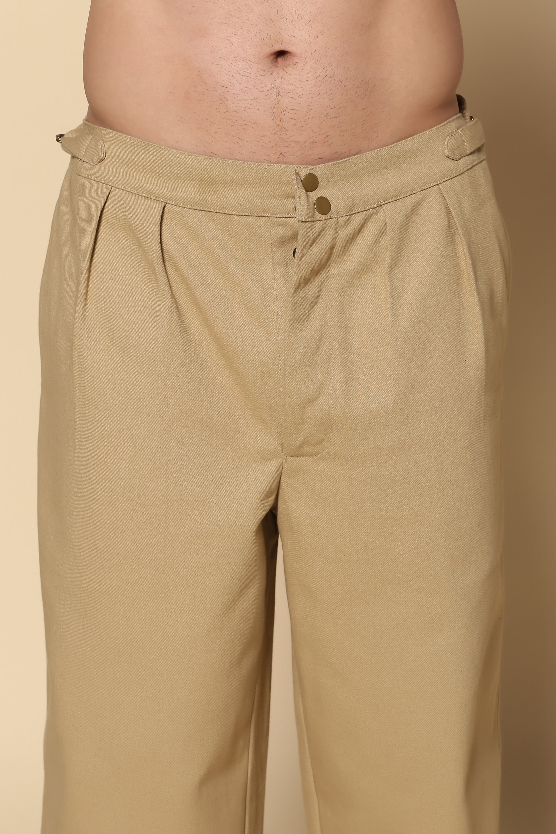 Beige pants worn by a person on a beige background