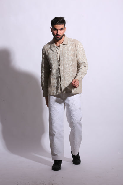Artisanal linen shirt for men featuring a polo collar and vintage-inspired lattice embroidery in a neutral sand tone.