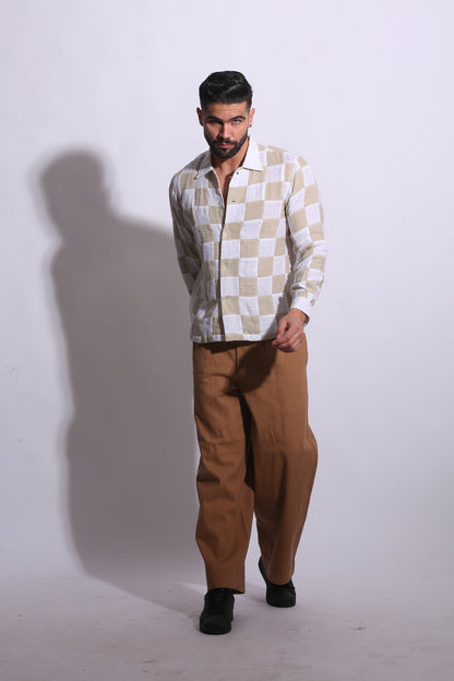 Close-up of a high-quality linen shirt showcasing a unique stitched patchwork checker pattern in beige and cream.