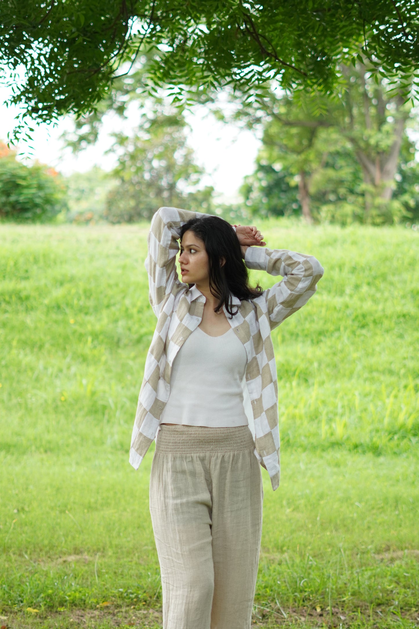 Front view of a cream and beige patchwork linen shirt against a white background, highlighting the button closure and cuffs.