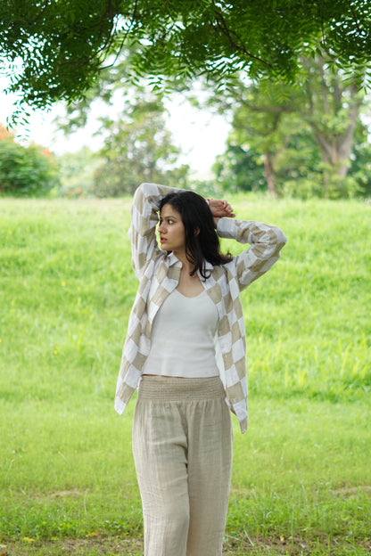 Front view of a cream and beige patchwork linen shirt against a white background, highlighting the button closure and cuffs.