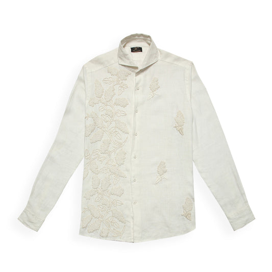 A white linen shirt with intricate hand embroidery in beige tone, displayed against a plain background.